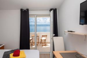 a room with a room with a view of the ocean at Beach Apartments Borovina in Stanići