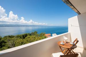 einen Balkon mit einem Tisch und Blick auf das Wasser in der Unterkunft Beach Apartments Borovina in Stanići