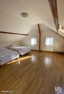 a room with two beds and a wooden floor at Les Falaises d'Etretat in Étretat