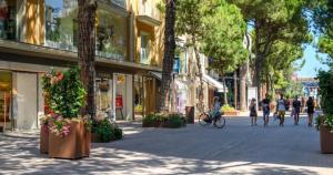 persone che camminano per strada in una città con edifici di BlancoHouse Viale Ceccarini a Riccione