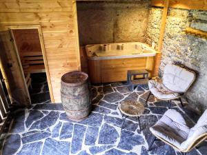 uma casa de banho com uma banheira, uma cadeira e um barril em Chez Lucienne em Samoëns