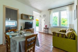 een keuken en een woonkamer met een tafel en stoelen bij Le Castagne Apartments Ischia in Ischia