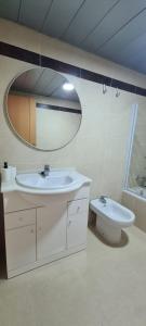 een badkamer met een wastafel, een toilet en een spiegel bij Apartamento Arena y Sal - Garrucha in Garrucha