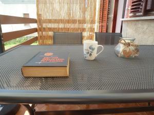 a book on a table with a cup and a mug at House Meli in Rakalj