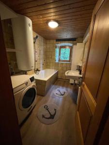 uma pequena casa de banho com uma banheira e um lavatório em Blue House em Ramingstein