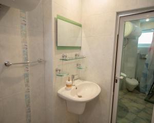 a white bathroom with a sink and a mirror at Aleks Holiday-center,sea,parking in Burgas City