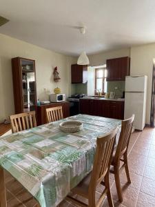 a kitchen with a table and chairs and a kitchen with a refrigerator at Camellia Guesthouse in Anilio Pelion