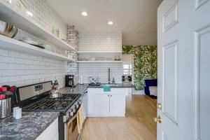 cocina con armarios blancos y fogones en Minneapolis Vacation Rental - 1 Mi to Downtown! en Minneápolis