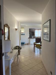 a living room with a table and a kitchen at Attico con terrazza in Via dei Traghetti in Lido di Ostia