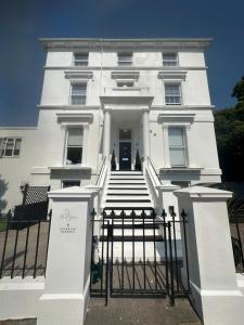 a white building with a gate in front of it at Boutique Nights in Eastbourne