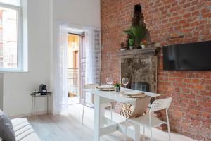 a living room with a white table and a brick wall at City Life Sweet Home - Fiera, Duomo in Milan