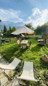 2 Stühle und ein Tisch mit Sonnenschirm in der Unterkunft La casa di Tommy in Savoulx