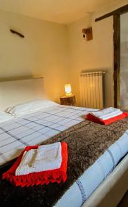 Schlafzimmer mit einem Bett mit einer roten und weißen Decke in der Unterkunft La casa di Tommy in Savoulx