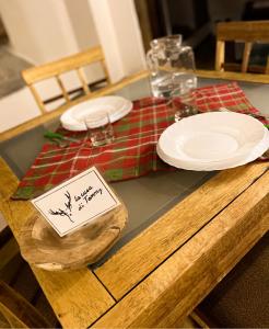 una mesa de madera con dos platos encima en La casa di Tommy, en Savoulx