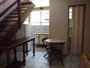 una pequeña cocina con una mesa y una escalera en Residencial Mogi das Cruzes, en Mogi das Cruzes