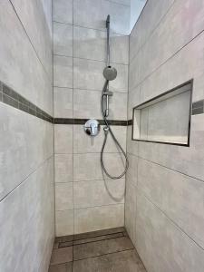 La salle de bains est pourvue d'une douche avec un pommeau de douche. dans l'établissement Apartment Brochenzell - nahe Ravensburger Spieleland, à Meckenbeuren