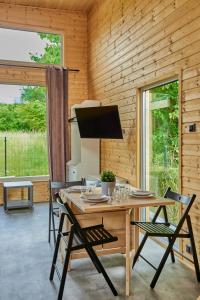 een houten eetkamer met een tafel en stoelen bij Domki RWL in Rewal