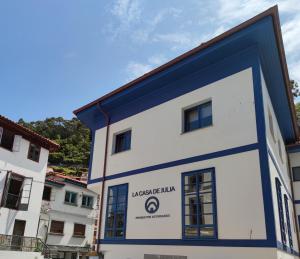 a large white building with a blue trim at Villa Cudillero - recep H Isabel in Cudillero