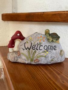 a rock sitting on a shelf with a welcome sign at Camellia Guesthouse in Anilio Pelion