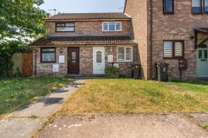 a brick house with a grassy yard in front of it at Cosy, Conveniently Located House by Dwell Haven - Close to Cardiff centre in Cardiff