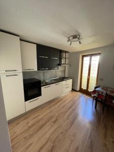 eine Küche mit weißen Schränken und Holzböden in der Unterkunft Appartamenti Top Life in Arco