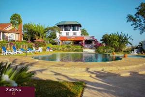 una piscina in un cortile con sedie e un edificio di LAIKIPIA WHITE HOUSE-NANYUKI a Timau