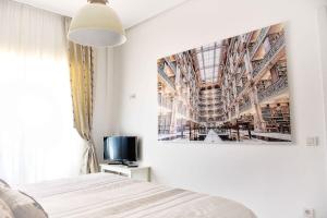 a bedroom with a bed and a picture on the wall at Apartamento LUXURY centro Bilbao GARAJE in Bilbao