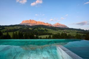 ein Schwimmbad mit Bergen im Hintergrund in der Unterkunft Badia Hill in Abtei