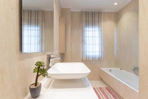 a bathroom with a toilet and a tub and a plant at Apartamento LUXURY centro Bilbao GARAJE in Bilbao