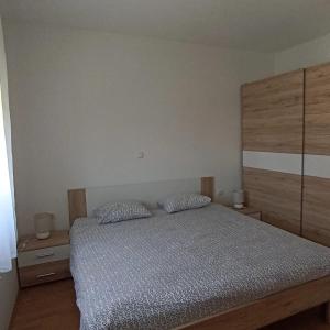 - une chambre avec un lit et 2 oreillers dans l'établissement Apartmani URANIJA, à Sveti Filip i Jakov