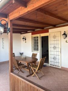 een patio met een houten tafel en stoelen bij Attico con terrazza in Via dei Traghetti in Lido di Ostia