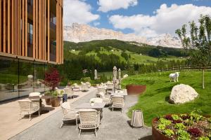een patio met tafels en stoelen met bergen op de achtergrond bij Badia Hill in Badia
