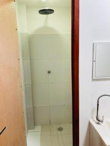 y baño con ducha y puerta de cristal. en HOSTAL AMA, en Leticia