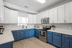 a blue and white kitchen with white cabinets at ☆Live on the Water! Lake Palmetto Palm w/ Patio - 10Min to Downtown & Beaches☆ in Charleston