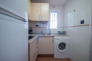 una cocina con lavadora y fregadero en Apartamento Cala Grande, en La Isleta del Moro