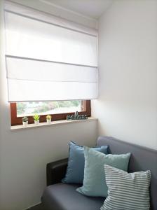 a window with a roller blind in a room with a couch at Slavica Olive 3 in Brodarica