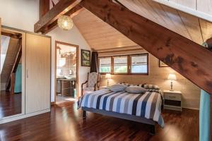- une chambre avec un lit dans une pièce dotée de plafonds en bois dans l'établissement B&B Le Sourire du Lac, à Sévrier
