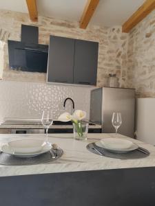 una cocina con 2 platos y copas de vino en una barra en White house, en Galižana