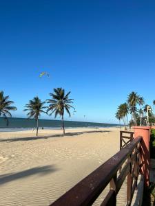 een zandstrand met palmbomen en de oceaan bij [Kariri 215] 46m², pé na areia, varanda vista mar! in Cumbuco