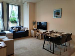 ein Wohnzimmer mit einem Tisch und einem Sofa in der Unterkunft Luxury Apartment Springhill Court Bewdley Worcestershire in Bewdley