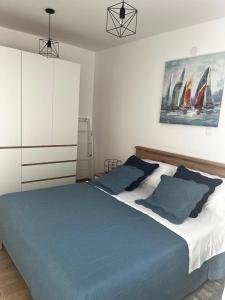 a bedroom with a large bed with blue pillows at Apartman Mila in Biograd na Moru