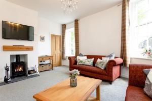 a living room with a couch and a fireplace at Algernon House in Alnwick