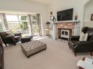 a living room with leather furniture and a fireplace at 9 Station Cottages in Belford