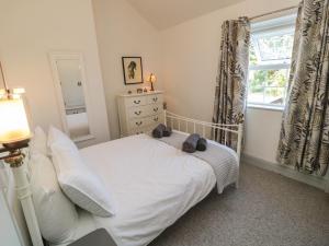 a bedroom with a white bed and a window at 9 Station Cottages in Belford