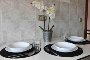 einen Tisch mit Tellern und Gläsern und eine Vase mit Blumen in der Unterkunft Casa vacacional Ajo in Ajo