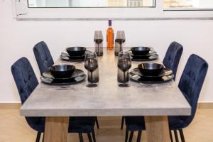 a dining room table with chairs and plates and wine glasses at Black Suites in Chania