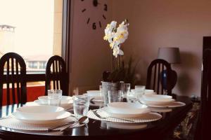 a dining room table with white plates and dishes on it at Casa vacacional Ajo in Ajo