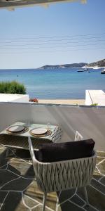 uma mesa e cadeira num pátio com vista para o oceano em Lemonia Rooms em Platis Yialos Sifnos