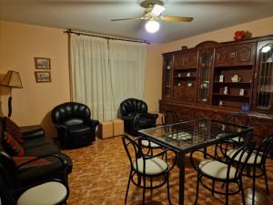 a living room with a glass table and chairs at Casa Rural La Malena in Cazalegas