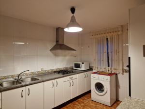 a kitchen with a sink and a washing machine at Casa Rural La Malena in Cazalegas